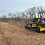 Helmick tractor mowing field